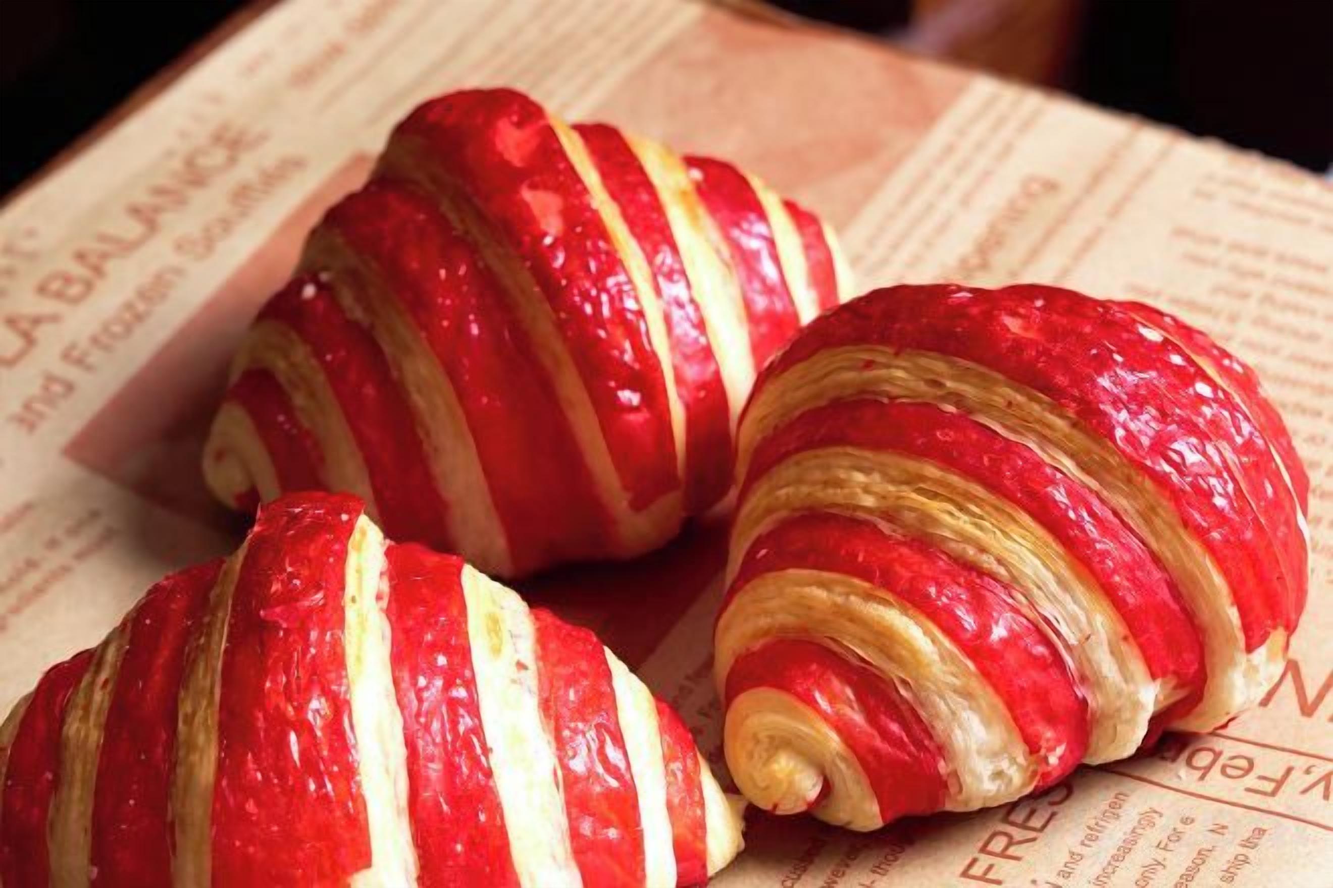 Tre croissanter med røde og hvide striber på en avis.