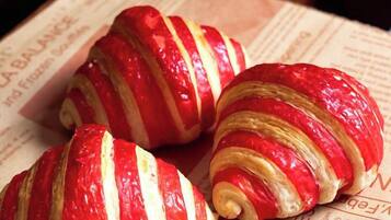 Tre croissanter med røde og hvide striber på en avis.