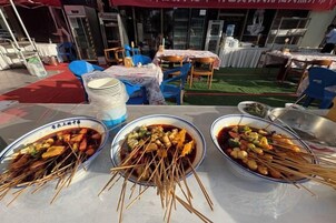A dining area with tables set for a meal, featuring bowls of food and chopsticks.