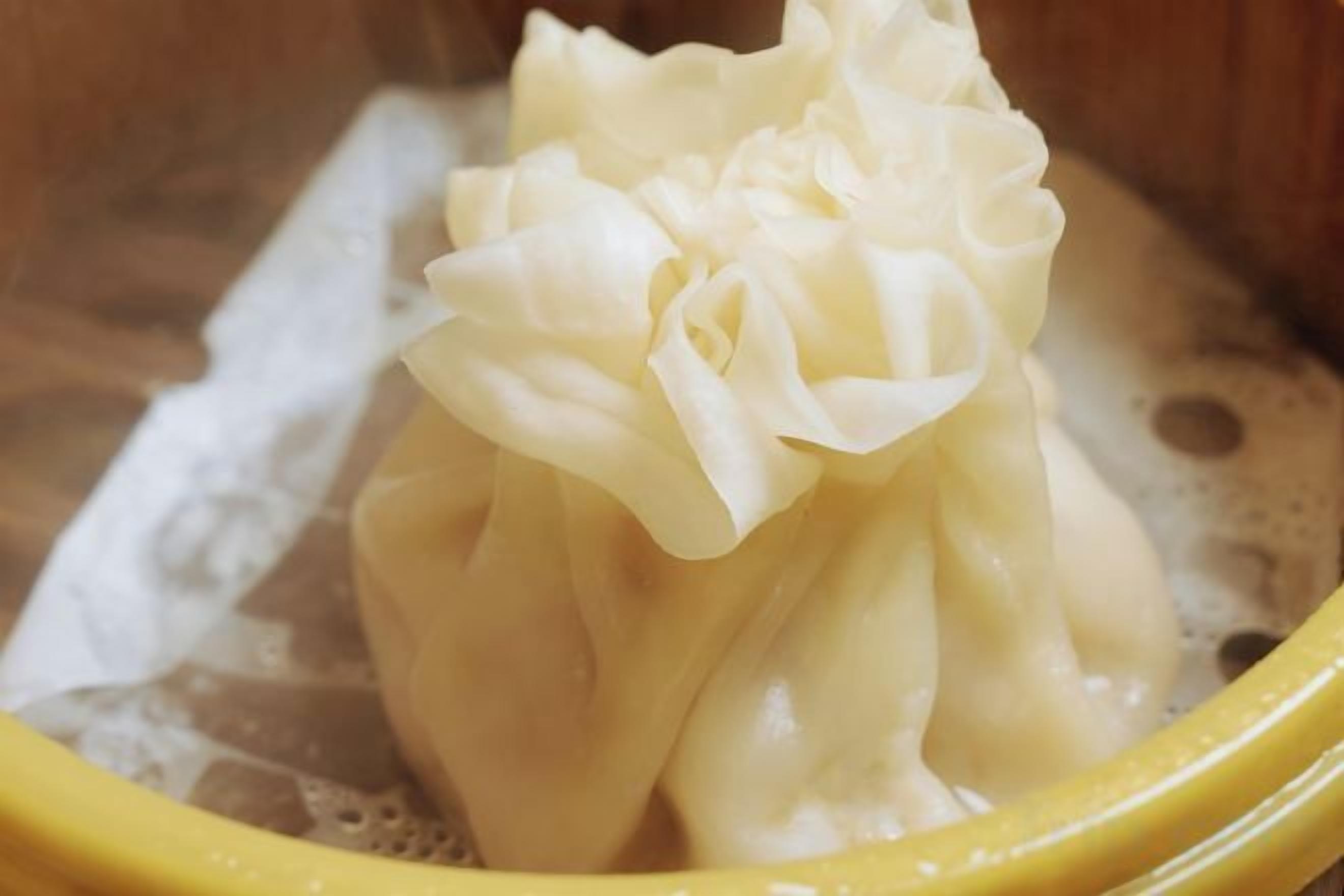 A yellow bowl containing a white, fluffy substance, possibly a food item, in a liquid environment.