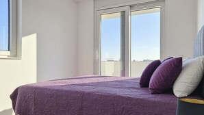 A bedroom with a bed, pillows, a nightstand, and a window. - Apartment Karlo by Interhome (Pag/Povljana)