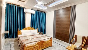 Ein Schlafzimmer mit einem hölzernen Bett, blauen Vorhängen, einer Klimaanlage und einem Deckenventilator.