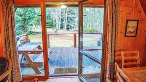 Eine Holzhütte mit Glastür, die auf eine Terrasss führt.