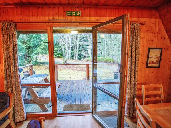 A wooden cabin with a glass door leading to an outdoor deck. - Birch Rowan Combi by Interhome (Drumnadrochit)
