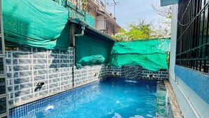 A swimming pool with tiled walls and a metal ladder. - Ananya Holidays Villa (Lonavala)