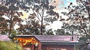 A house with a covered patio, solar panels, and a fenced yard. - Hot spa with Ocean Views - fire pit - 
2 fully equipped retreats - privacy  (Bonogin)