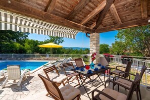 An outdoor patio area with a pool, lounge chairs, and a table set for dining. - Villa Ester - Private Pool Escape for 8 (Krsan)