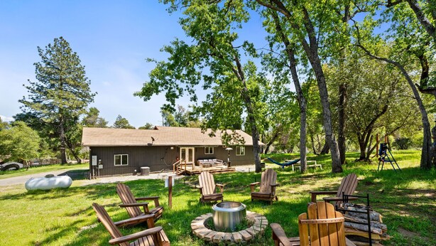 A cabin with a deck, outdoor seating, and a fire pit. - Cozy Cabin! BBQ • Spa • Fire Pit • Kids Play Zone (Mariposa)