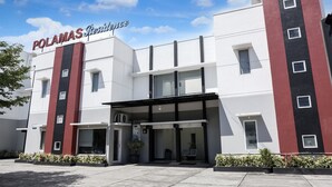 Um hotel moderno com uma placa de destaque que diz 'POLAMAS Residences'.
