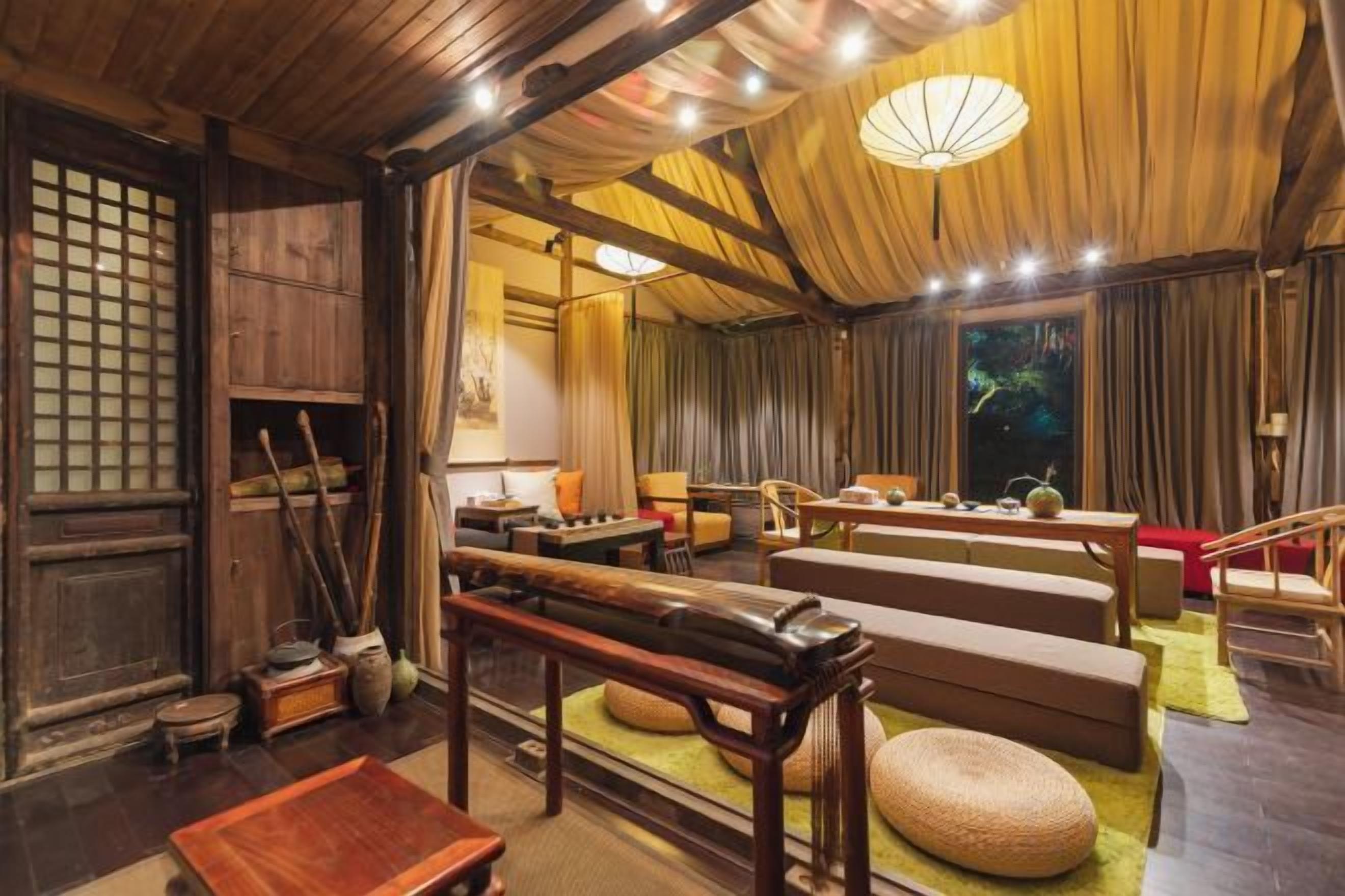 A traditional Japanese-style room with tatami flooring, a low table, cushions, and a sliding door.