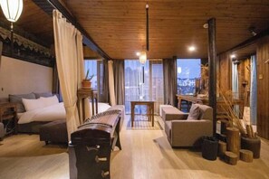 Una habitación acogedora con una cama, un piano, un sofá y vistas a la ciudad.