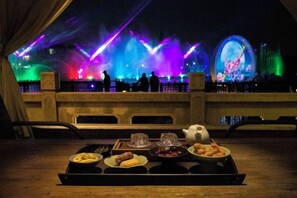 A dining table with a tray of food and drinks, set against a backdrop of a stage with colorful lighting and a large circular light display. - Yueshang Zen Space Homestay (Zhouzhuang Ancient Town Branch) (Kunshan)