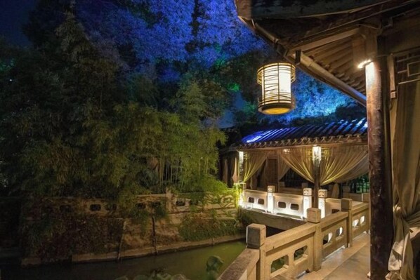 A traditional Japanese-style building with a wooden structure, a lantern, and a stone bridge over a water body. - Yueshang Zen Space Homestay (Zhouzhuang Ancient Town Branch) (Kunshan)