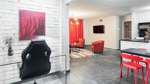 A modern kitchen with a black countertop, red chairs, and a red abstract painting on the wall. - 1BR W Alabama Montrose Sueño Apt 6, Med Center! (Houston)