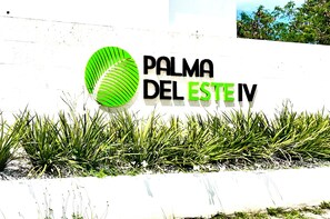 A sign with the text 'PALMA DEL ESTE IV' and a green palm leaf logo. - Rooftop Bliss Cozy 2-bedroom condo in soothing Punta Cana with private rooftop (Punta Cana)
