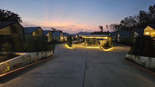 A resort with multiple bungalow-style accommodations, a central building with a covered patio, and a paved driveway leading to the entrance. - Nararin.Phuket/ Family house (Phuket)