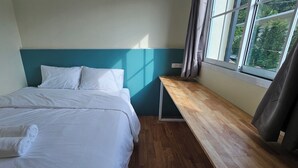A neatly made bed with white linens, a wooden bench, and a window with curtains. - Nararin.Phuket/ Family house (Phuket)
