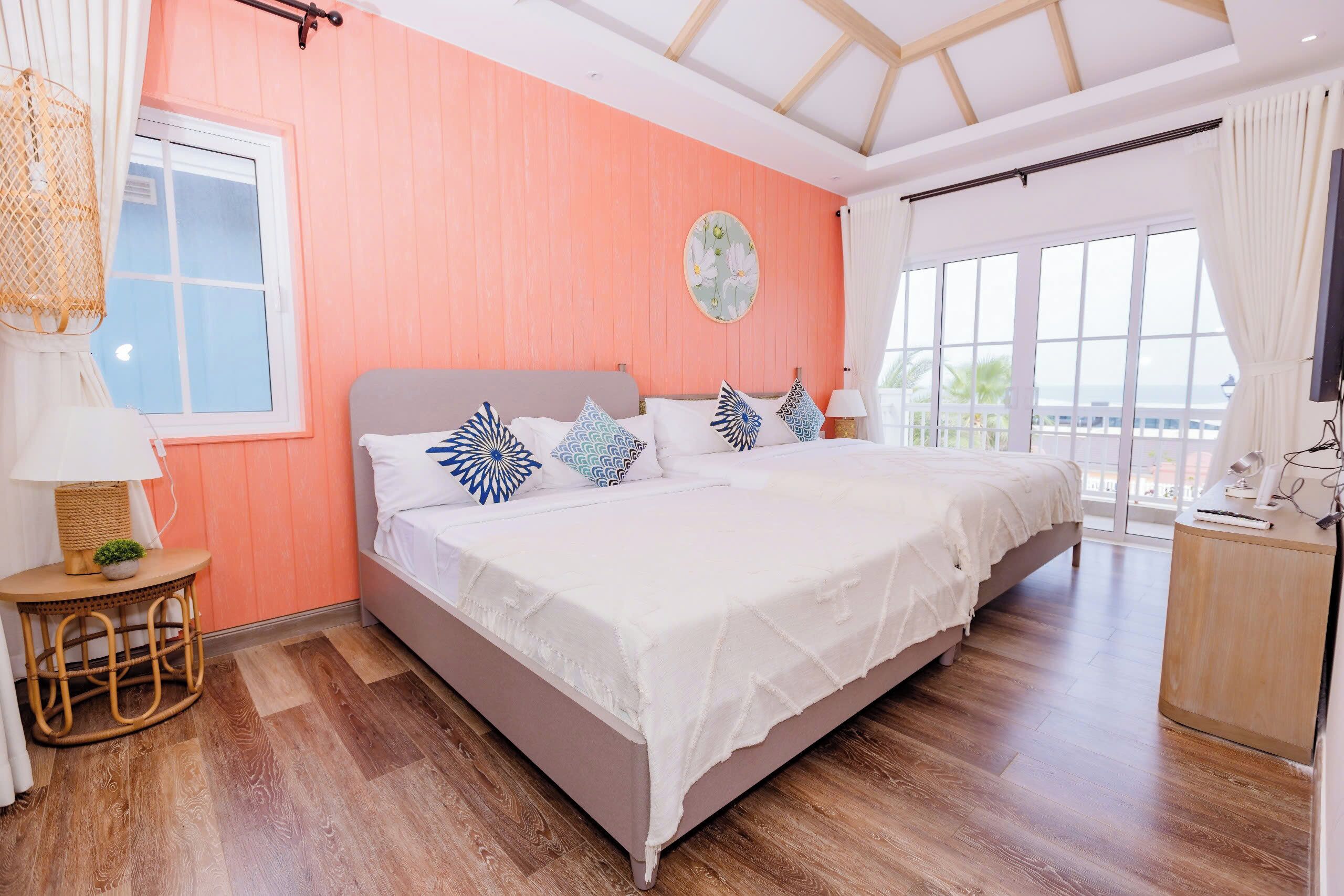 A bedroom with a bed, bedside tables, a window, and a view of the outside.