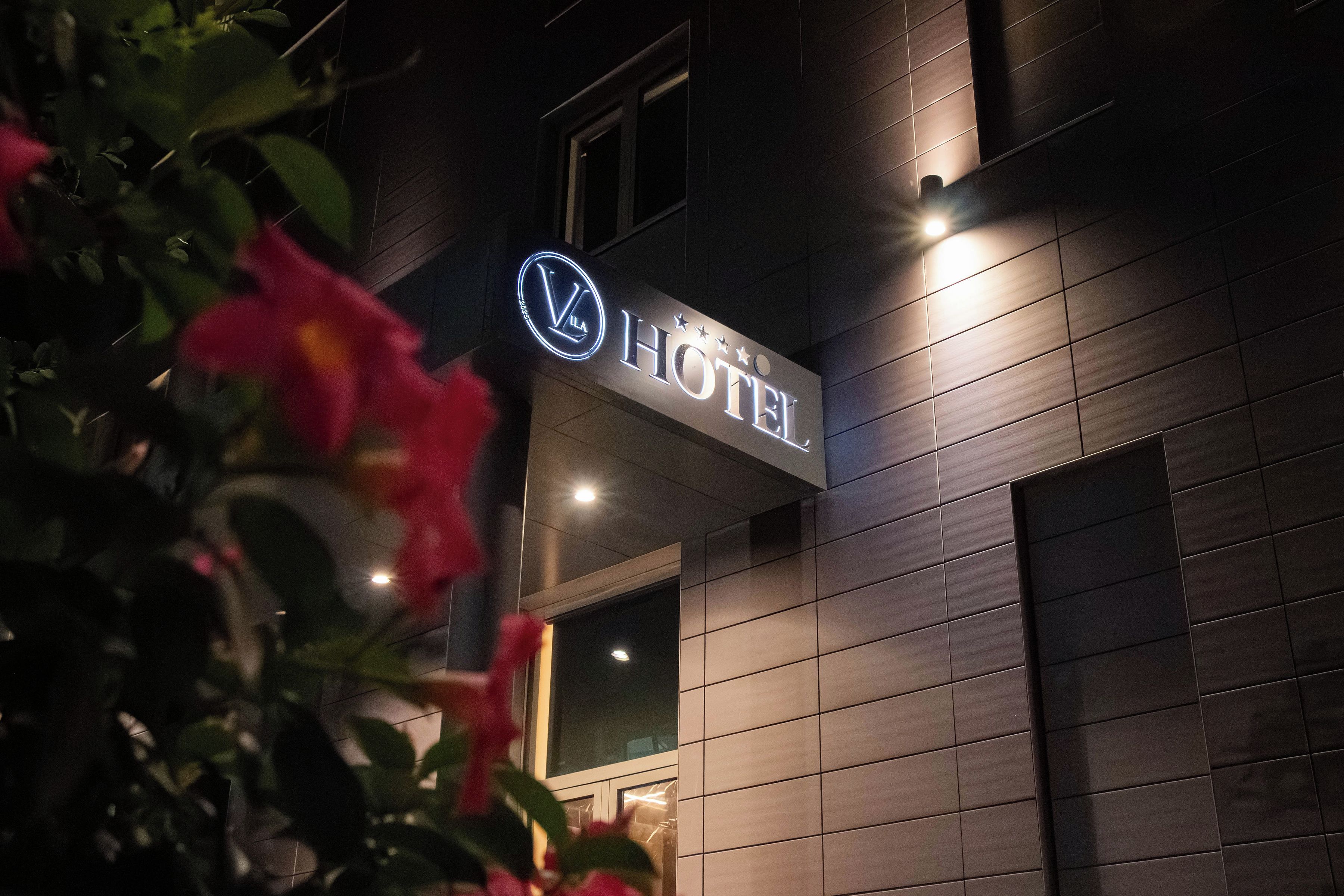 A hotel sign with a logo and the word 'HOTEL' illuminated.