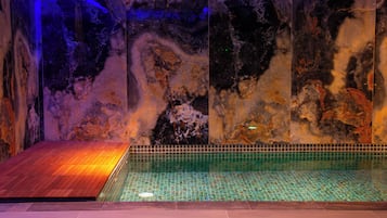 Una piscina techada, sillones reclinables de piscina