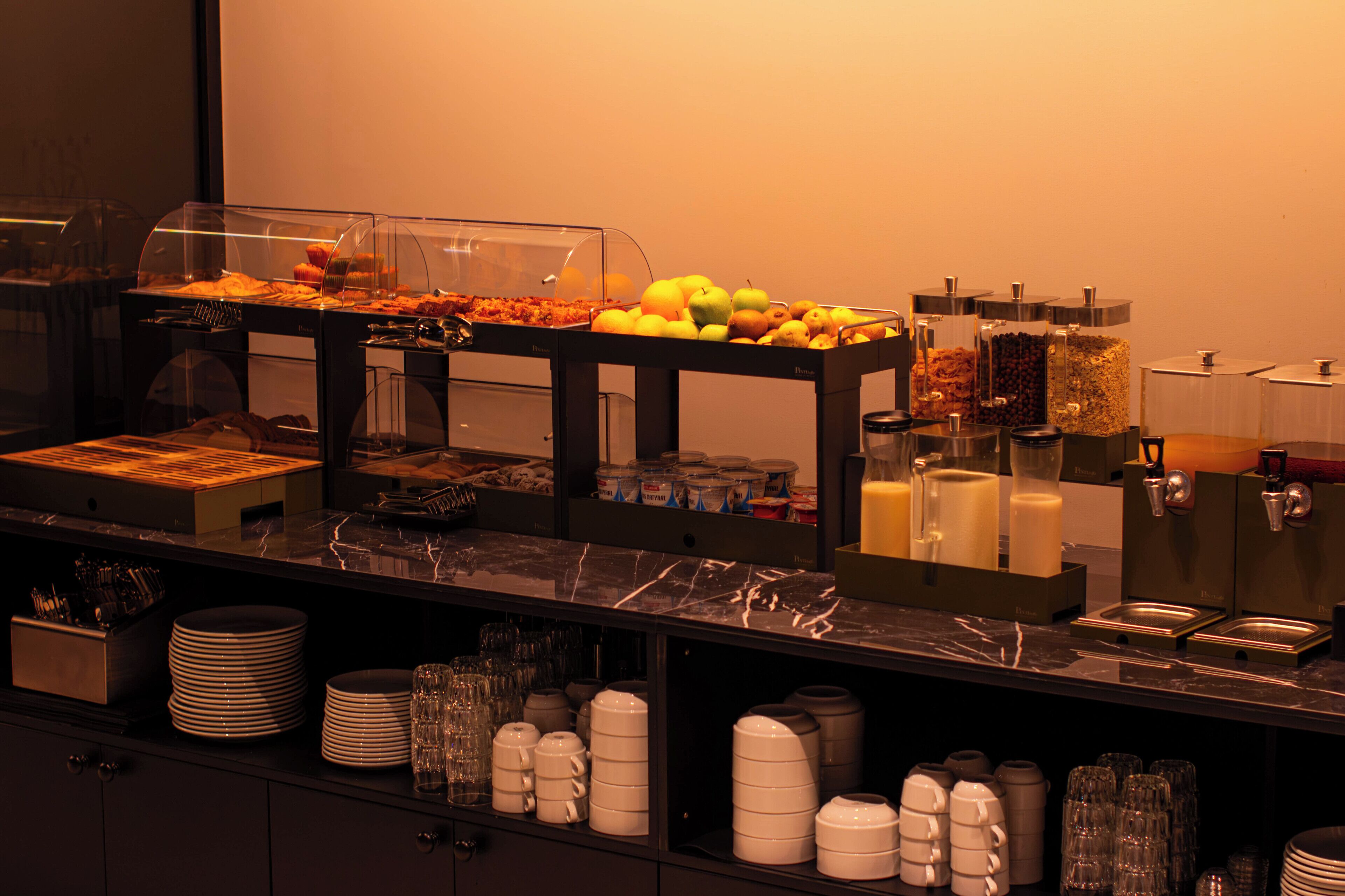 Buffet com diversos alimentos e um espaço para café.