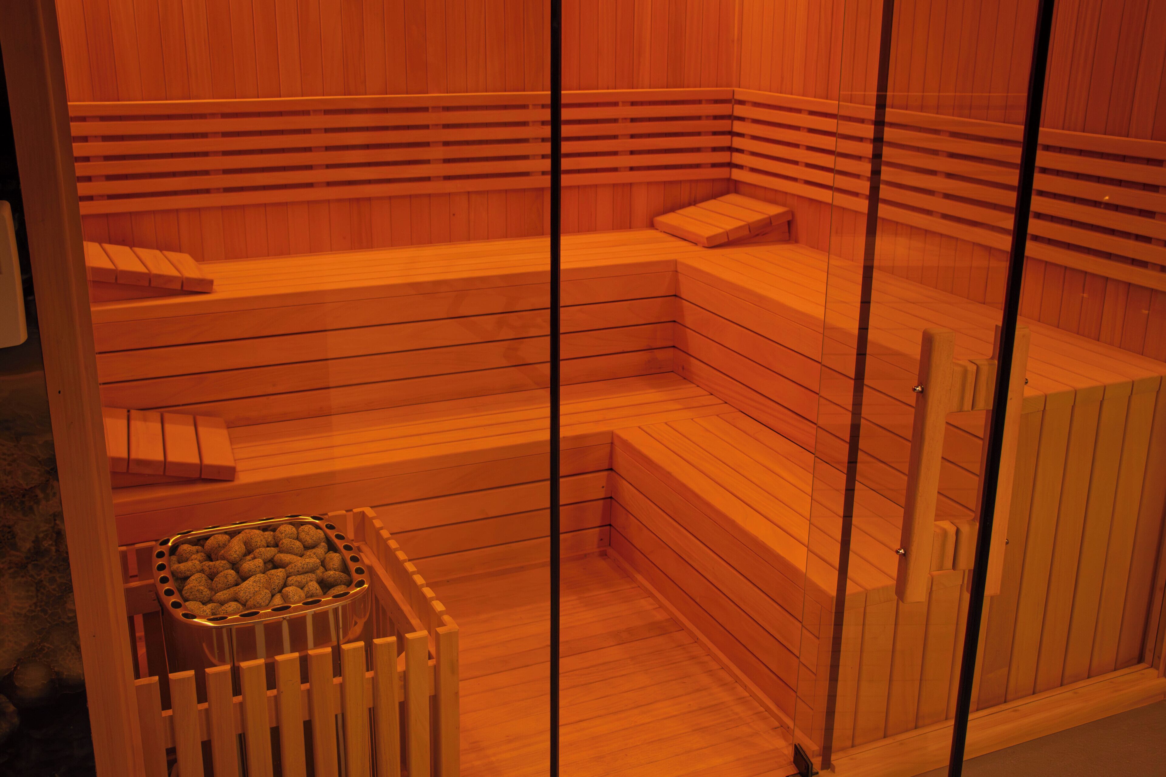 Una sauna con bancos de madera y un recipiente pequeño de sales de baño.