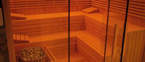 Una sauna con bancos de madera y un recipiente pequeño de sales de baño.