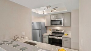 Una cocina moderna con electrodomésticos de acero inoxidable, horno empotrado y microondas.