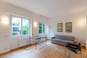 A modern living room with a glass dining table, a grey sofa, and a black chair. - 2 Flats Combined Spacious Family Retreat (Santa Margherita Ligure)
