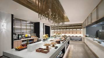 Cozinha moderna com ilha central grande, eletrodomésticos de aço inoxidável e luminária pendente.