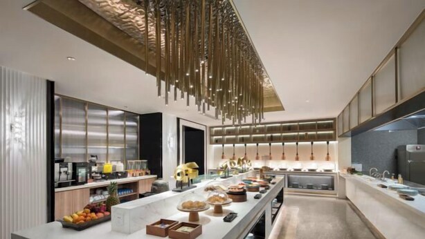 A modern kitchen with a long island, stainless steel appliances, and a hanging light fixture. - Shanghai Citadines Hotel (Lujiazui Financial District Beiyangjing Road Subway Station Branch) (Shanghai)