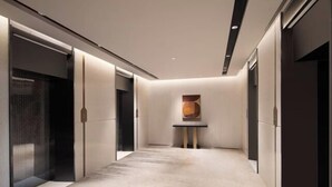A modern hallway with a textured floor, a small table with a vase, and a wall-mounted artwork. - Shanghai Citadines Hotel (Lujiazui Financial District Beiyangjing Road Subway Station Branch) (Shanghai)