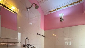 A bathroom with a sink, toilet, shower, and a mirror. - 555 Home Stay and Restaurant (Burhanilkantha)