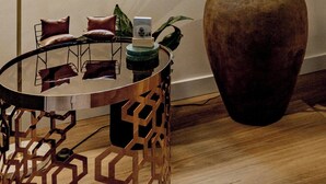 A room with a large potted plant, a round table with chairs, and a floor lamp. - The 'Gordon House' Prestige Experience (Melbourne)