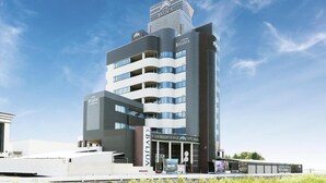 A modern hotel with a prominent 'Byllyu' sign, multiple balconies, and a view of the surrounding area. - Hotel Bvljua -leisure hotel- Adults Only (Kurume)
