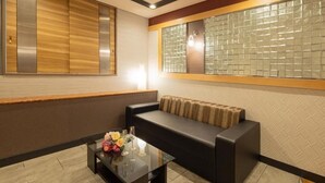 A modern room with a sofa, a glass coffee table, and a large window with a patterned view. - Hotel Bvljua -leisure hotel- Adults Only (Kurume)