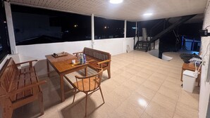 A spacious balcony with a wooden table, chairs, and a chessboard. - D6 Apartment at the Pier 4 of 6 (Ko Pha-ngan District)