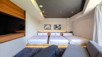 A hotel room with two beds, a bench, a TV, and artwork on the wall.