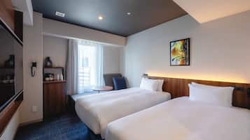 A hotel room with two beds, a desk, a chair, a small table, a painting, and a window with curtains.