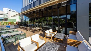 An outdoor patio area with seating, tables, and a glass enclosure.