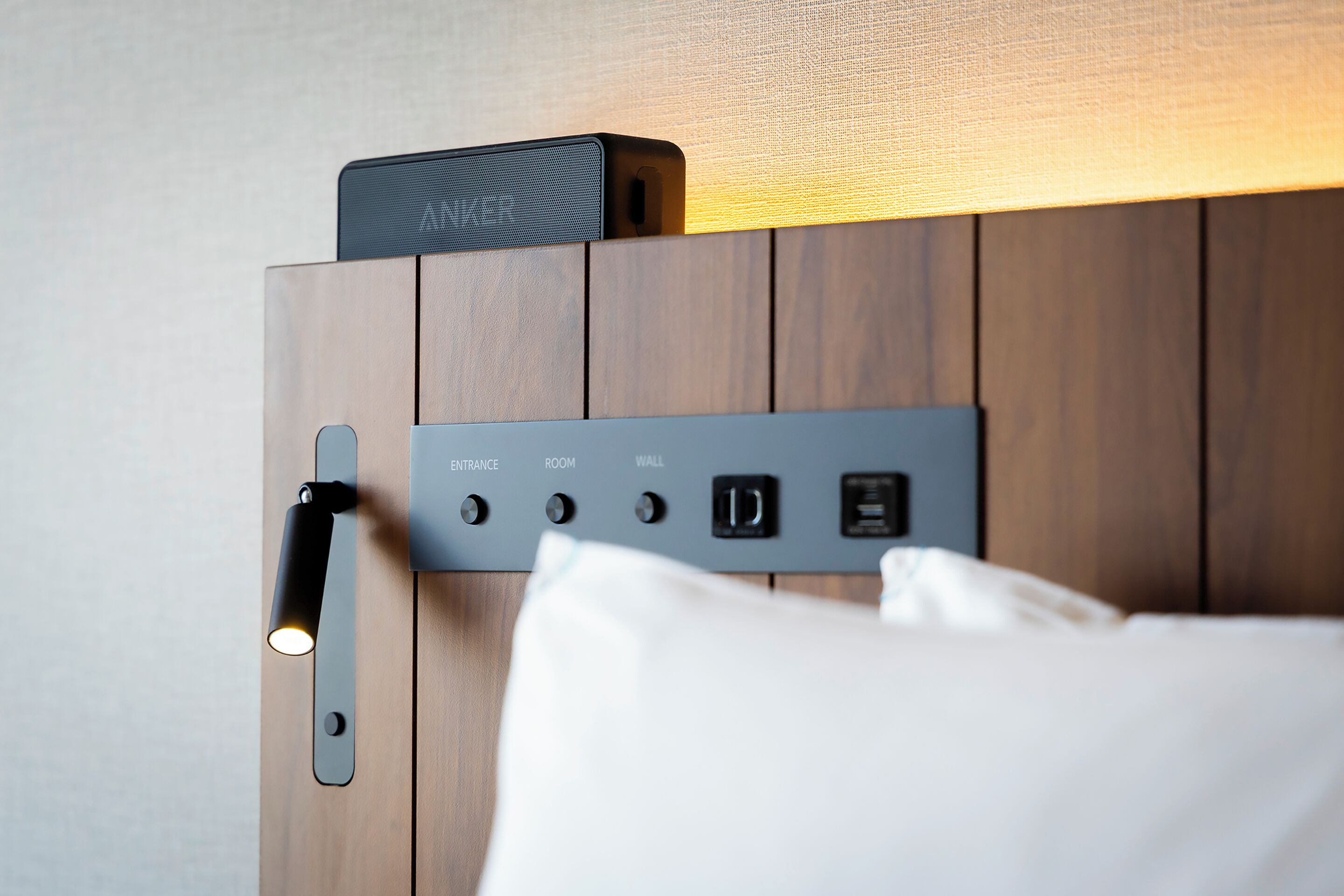 A wall-mounted control panel with labeled buttons for 'ENTRANCE,' 'ROOM,' 'WALL,' and 'POWER' on a wooden panel wall.