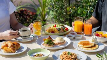 A breakfast table with various dishes, including eggs, toast, and fruit.
