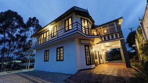 A two-story house with a balcony, a driveway, and a satellite dish. - Alaya Stays Cleft 3BHK with Garden (Kotagiri)