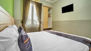 A hotel room with a bed, a wardrobe, a TV, and a window with curtains. - Hotel O near Juanda Airport formerly Azz (Sidoarjo)