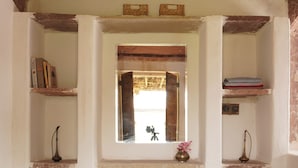 A room with a window, shelves, a woven basket, and a patterned floor.