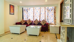 A living room with a sofa, two side tables, and a glass coffee table. -  Shivraj Hotel Mussoorie (Mussoorie)