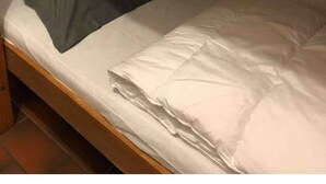 Un letto a castello con un cuscino e una coperta.