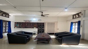 Un'ampia stanza con una reception, due divani, un tavolo e una ventola a soffitto.