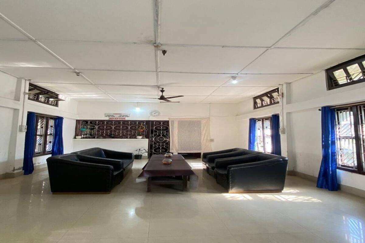 A spacious living room with a sofa set, a coffee table, and a ceiling fan.