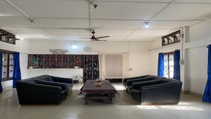 Un'area reception con una scrivania, due divani neri, un tavolino da caffè e una ventola a soffitto.